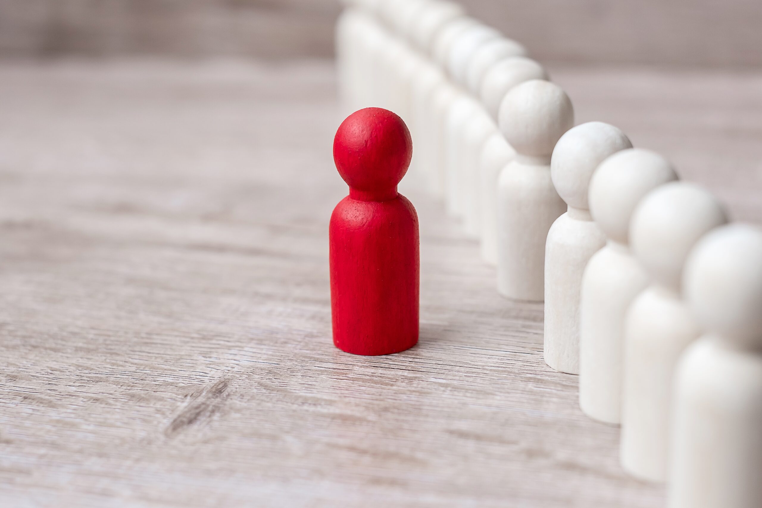 red leader businessman with crowd of wooden men