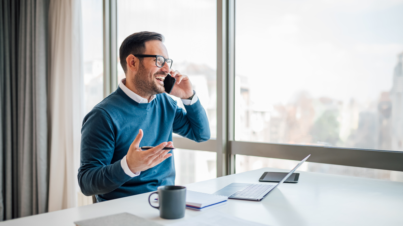 happy businessman securing new business over mobile phone