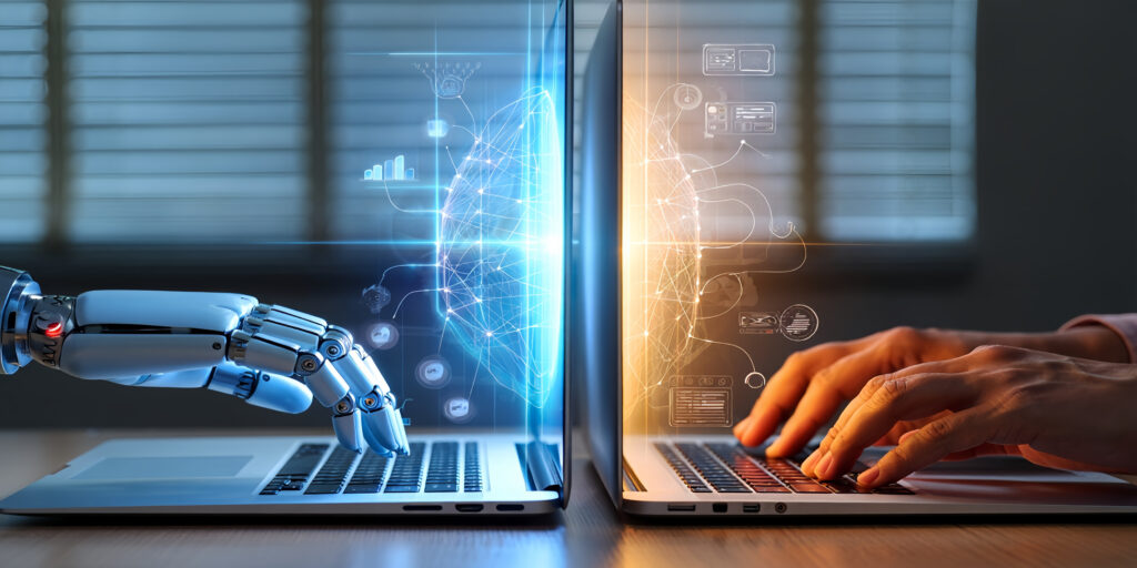 human hand and robotic hand at separate laptops
